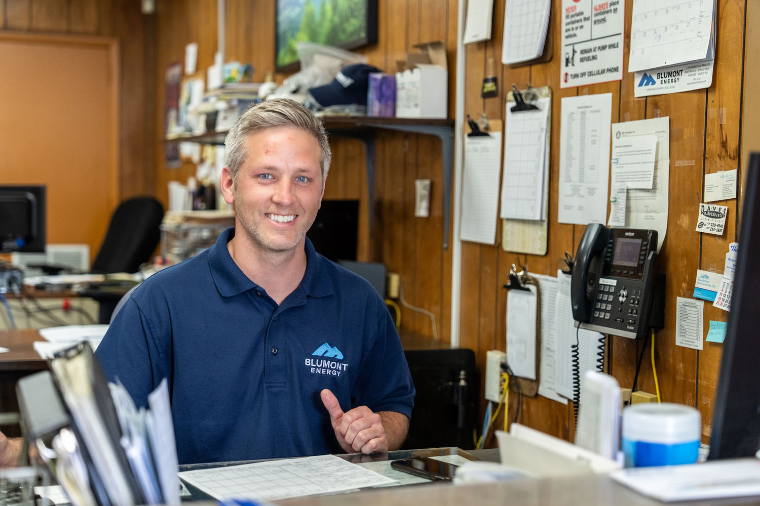 happy employee at their desk looking at the camera