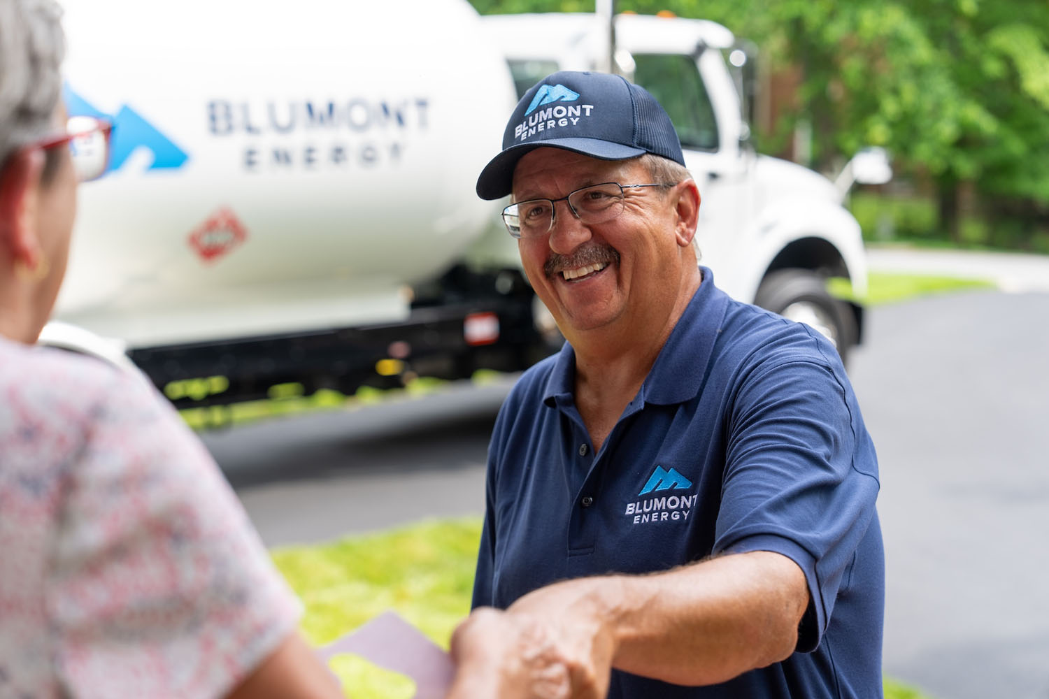 happy Blumont Energy service technician shaking hands with a customer