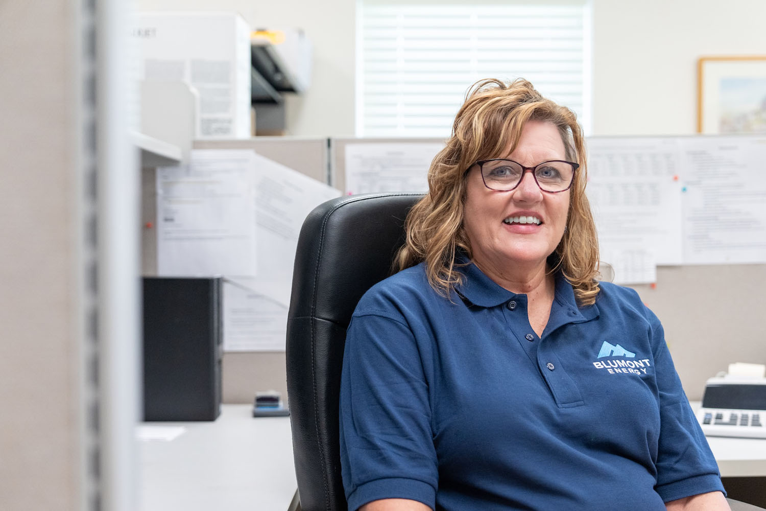 happy employee at their desk looking at the camera