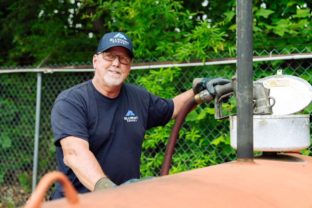 Happy Blumont Energy service technician filling up a tank