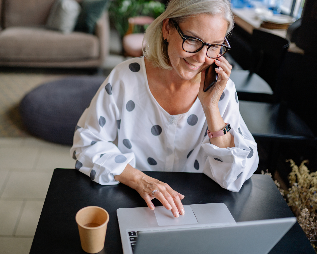 woman on cell phone and looking at laptop